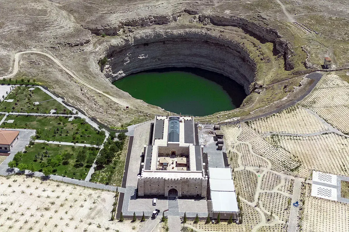 Aerial photograph showing an 800-year-old Seljuk caravanserai turned hotel in front of the Kizoren sinkhole in Karapinar, Konya province, Türkiye.