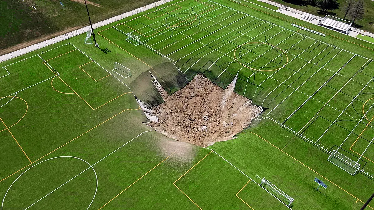 Aerial view of a sinkhole that opened on a soccer field in Alton, Illinois, United States, used in the article to illustrate global sinkhole occurrences