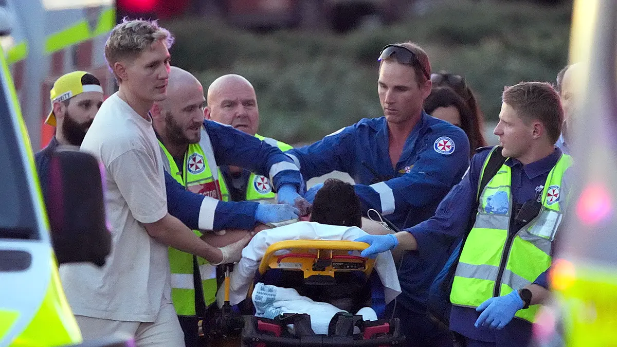 Emergency medical workers assisting an injured person on a stretcher after the Bondi Beach mass shooting in Sydney
