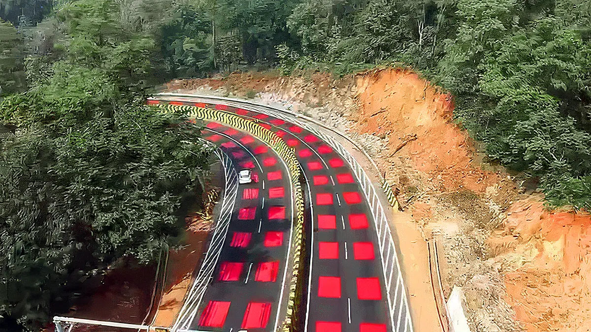 Curved mountain highway with red tabletop road markings to slow vehicles