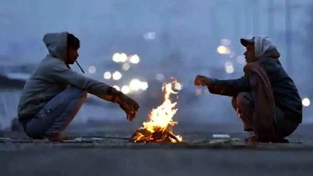 People warming themselves around a roadside fire in Telangana during the intense winter cold wave.